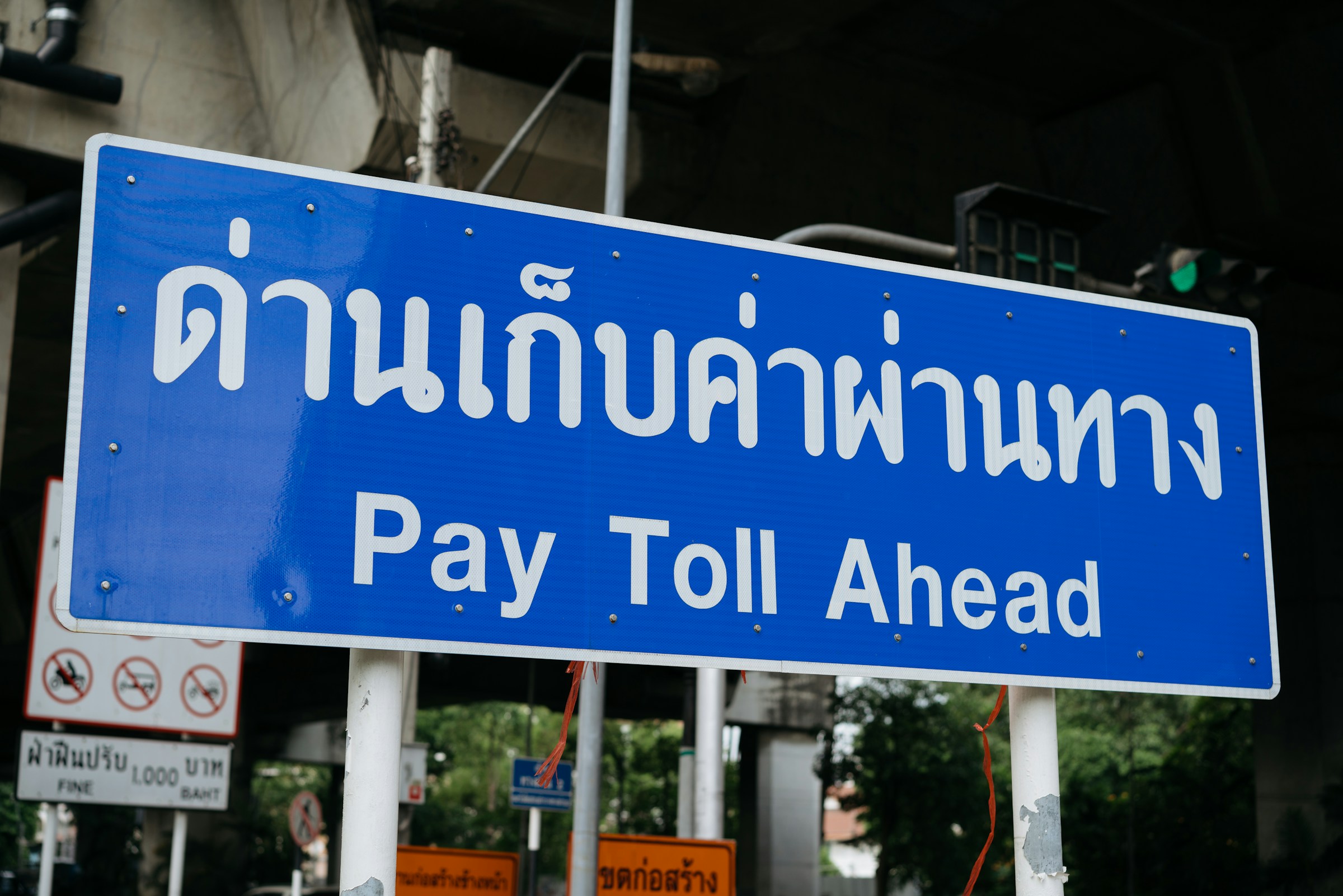 "Pay Toll Ahead" on a Bangkok expressway. Under the global minimum tax, the notice now applies to the region's investors: the free ride on tax is ending.